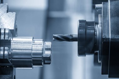 CNC Torna Makinesi, açık mavi sahnedeki metal şaft parçalarını kesti. CNC dönüşüm makinesiyle çalışan yüksek teknoloji metali.