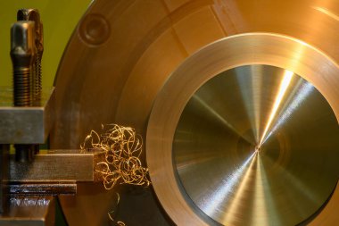 Closeup scene the lathe machine finish cut the brass parts by lathe tools. The metalworking process by turning machine.