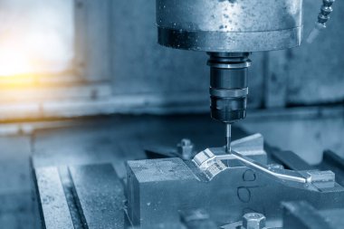 CNC değirmen makinesi ışık efektli açık mavi sahnede sert top burun değirmeni ile küf parçası kesiyor. Kalıplar, sert top değirmeni ile makine merkeziyle kesme işlemi yapıyor.