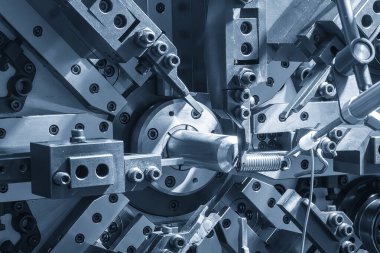 Açık mavi sahnede tel bobini yay yapma makinesini kapatın. Mekanik parça üretim konsepti.