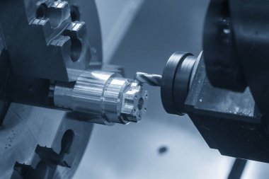 CNC Torna Makinesi, açık mavi sahnedeki metal şaft parçalarını kesti. CNC dönüşüm makinesiyle çalışan yüksek teknoloji metali.