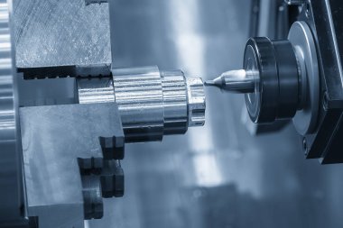 CNC Torna Makinesi, açık mavi sahnedeki metal şaft parçalarını kesti. CNC dönüşüm makinesiyle çalışan yüksek teknoloji metali.