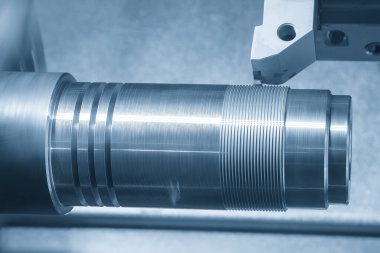 CNC torna makinesi açık mavi sahnede metal şaft parçalarını kesiyor. CNC dönüşüm makinesinin yüksek teknolojili metal işlemesi .