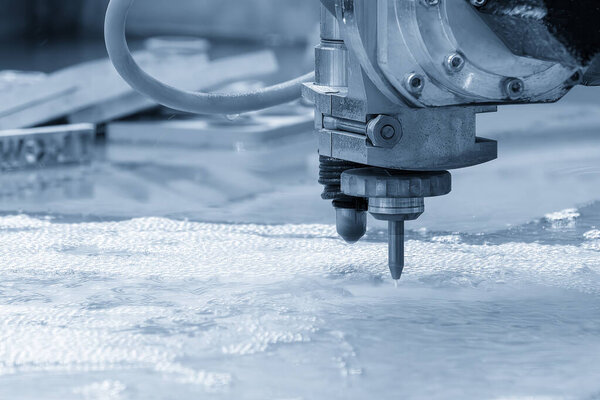 Крупный план многоосного абразивного гидрорежущего станка для резки алюминиевой пластины. Высокотехнологичный листовой металл с ЧПУ.