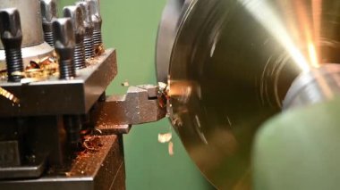 Ağır çekim sahnesi. Torna makinası pirinç parçaları kesmiş. Makineyi döndürerek metal işleme süreci.