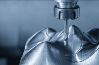 CNC değirmen makinesi açık mavi sahnede metal parçalarını top burun değirmeni aletleriyle kesiyor. Küf parçalarını kesen CNC değirmen makinesi.