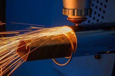 Sahneyi kapatın, fiber lazer kesme makinesi paslanmaz çelik tüpü ve parlak ışığı kesti. Lazer kesme makinesinin yüksek teknoloji metal üretim süreci.. 