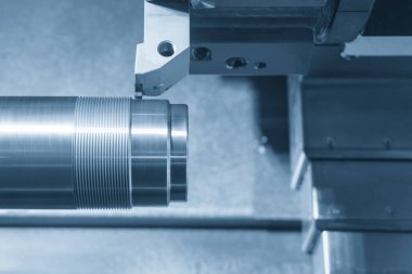 CNC Torna Makinesi 'nin kapanış sahnesinde açık mavi sahnede metal şaft parçalarını kesiyor. CNC dönüşüm makinesi tarafından çalışan yüksek teknolojili metal işleme .
