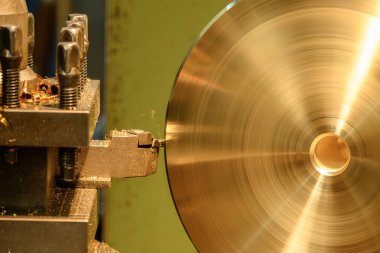 Torna makinesinin bitirdiği sahneyi kapat pirinç maddi parçaları kes. Makineyi döndürerek metal işleme süreci.