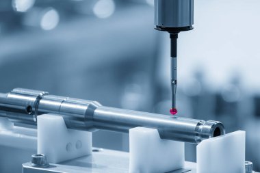 Açık mavi sahnedeki metal şaft parçalarını ölçen CMM makinesi. CMM makinesiyle otomotiv parçalarının kalite kontrolü