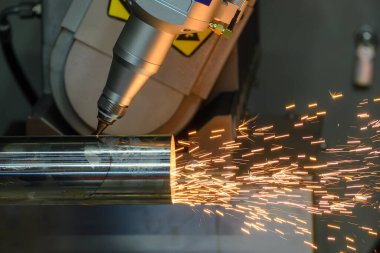 Sahneyi kapatın. Çoklu eksen fiber lazer kesme makinesi paslanmaz çelik tüpü parlak ışıkla kesti. Lazer kesme makinesinin yüksek teknoloji metal üretim süreci.. 