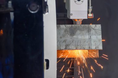 Yan görüntü, fiber lazer kesme makinesi kare şeklindeki paslanmaz çelik tüpü parlak ışıkla kesti. Lazer kesme makinesinin yüksek teknoloji metal üretim süreci.. 