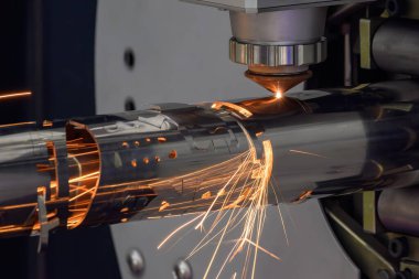 Sahneyi kapatın, fiber lazer kesme makinesi paslanmaz çelik tüpü ve parlak ışığı kesti. Lazer kesme makinesinin yüksek teknoloji metal üretim süreci.. 