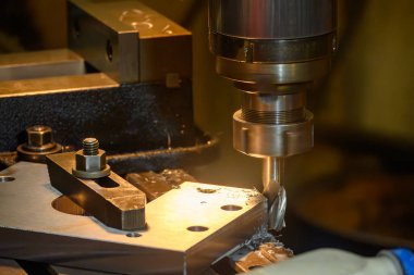 NC değirmen makinesindeki metal operasyonu. NC değirmen makinesi, metal parçalarını düz burun değirmeni araçlarıyla kesiyor..