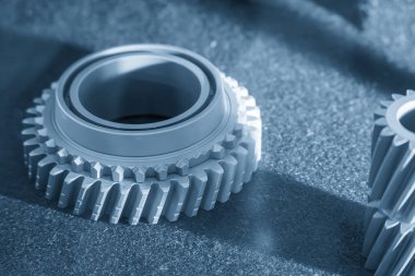 Açık mavi sahnede, metal 3D baskı metodundan küçük vites şekilli sahneyi kapatın. Hızlı prototip yöntemi ile katkı maddesi üretim süreci.