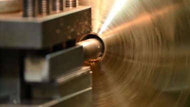 Ağır çekim sahnesi. Sıkıcı alet pirinç maddi kısımlarda delik açıyor. Torna makinesinin metal çalışma süreci.