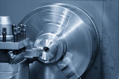 Kapanış sahnesinde torna makinası, açık mavi sahnedeki metal parçaları kesmiş. Makineyi döndürerek metal işleme süreci.