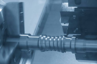 CNC torna makinesinin kanalı açık mavi sahnede metal top vida şaft parçalarını kesiyor. CNC dönüşüm makinesinin yüksek teknolojili metal işlemesi .