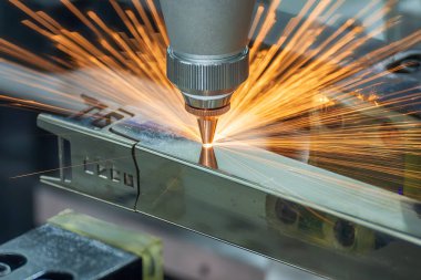 Sahneyi kapatın, fiber lazer kesme makinesi kare şeklindeki paslanmaz çelik tüpü parlak ışıkla kesti. Lazer kesme makinesinin yüksek teknoloji metal üretim süreci.. 