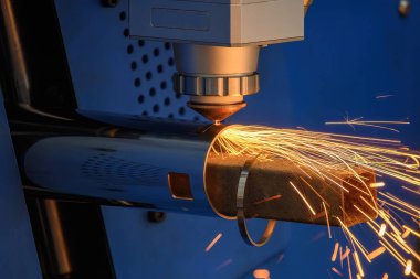 Sahneyi kapatın, fiber lazer kesme makinesi paslanmaz çelik tüpü parlak ışıkla kesti. Lazer kesme makinesinin yüksek teknoloji metal üretim süreci.. 