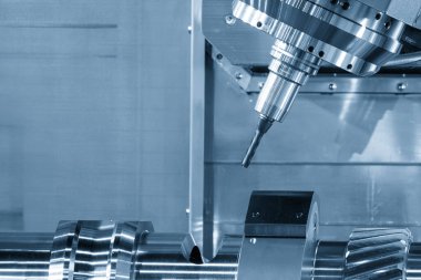 Çok görevli CNC makinesi, açık mavi sahnede metal dişli parçalarını düz burun değirmeni ile kesiyor. Çoklu görev CNC makinesiyle otomotiv parçaları üretim süreci. 