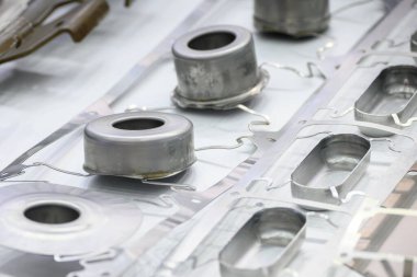 İlerici zarda metal çizim sürecinin bir parçasını damgalamak. Sahneyi kapat. Metal oluşum süreci aşamalı ölüm ile devam ediyor..