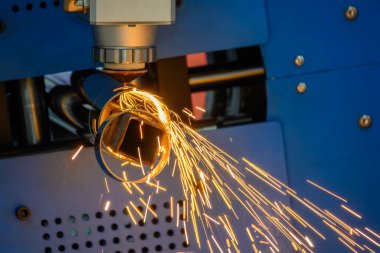 Sahneyi kapatın, fiber lazer kesme makinesi paslanmaz çelik tüpü parlak ışıkla kesti. Lazer kesme makinesinin yüksek teknoloji metal üretim süreci.. 
