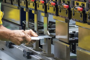 Bükme makinesi operatörünü kapatın metal levha parçalarını tutun. Yetenek operatörünün kullandığı levha metal çalışması.