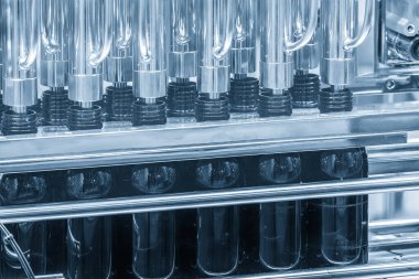 Doldurma işlemi için taşıyıcı banttaki boş siyah içki şişeleri. İçme suyu üretim sürecinin yüksek teknolojisi. 