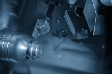 CNC torna makinesi, açık mavi sahnedeki metal küf parçalarını kesiyor. CNC dönüşüm makinesi tarafından çalışan yüksek teknolojili metal işleme .