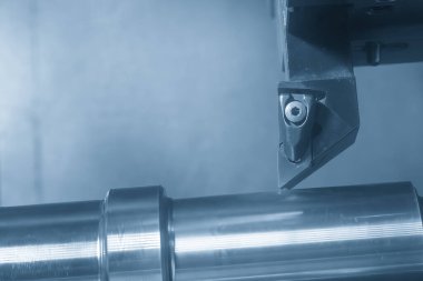 CNC Torna Makinesi, açık mavi sahnede metal şaft parçalarını kesiyor. CNC dönüşüm makinesiyle çalışan yüksek teknoloji metali.