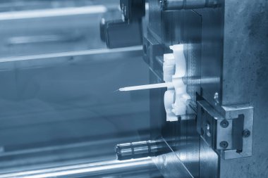 Açık mavi sahnedeki enjeksiyon makinesinin plastik parçalarını kapatın. Plastik enjeksiyon küf makinesinin otomotiv parçaları üretim süreci.