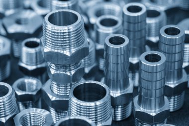 Sahneyi kapatın. Altıgen, paslanmaz çelik boru bağlantısı açık mavi sahnede. Tesisat ekipmanı üretim konseptleri.