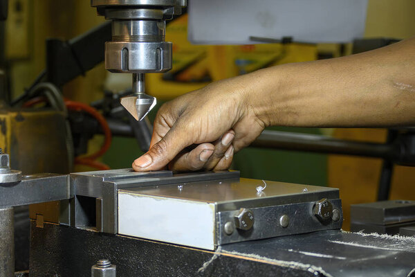 The machine operator working with NC milling machine. The machine operator change the cutting tool on NC milling machine. 