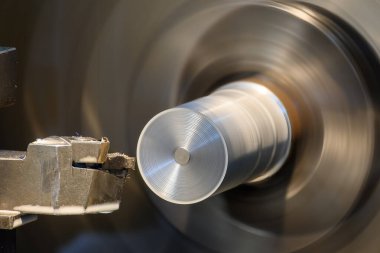 Torna makinesi metal şaft parçalarını sıvı soğutucu metoduyla kesiyor. Makineyi döndürerek metal işleme süreci.