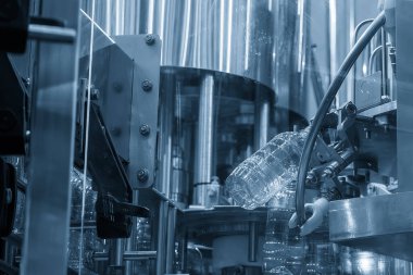 Açık mavi sahneyi doldurmak için konveyör bandındaki boş içme suyu şişeleri. İçme suyu üretim sürecinin yüksek teknolojisi. 