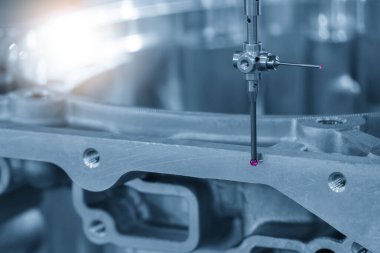 Otomotiv parçalarını mavi tonda modüler sondayla ölçen CMM makinesi. CMM makinesiyle otomotiv parçalarının kalite kontrolü