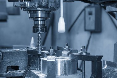 Delik delme işlemi, değirmen makinesinin pirinç maddi parçalarını mavi tonda matkapla delme aracıyla işliyor. Değirmen makinesindeki metal çalışma konsepti..