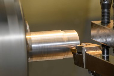 Yakından bakınca torna makinesi metal parçaları kesmiş. Makineyi döndürerek metal işleme süreci.