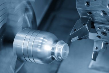 CNC torna makinesinin oluşturduğu, metal şaftın mavi tondaki kısmını kestiği sahneyi kapatın. Yüksek teknoloji metal işleme makinesini döndürerek çalışır..