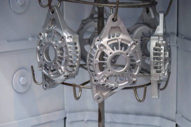 Olay yeri temizleme ve yüzey oyma işlemi kum püskürtme makinesindeki jeneratör parçalarını işliyor. Otomotiv parçaları üretimi kavramları.