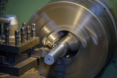 Torna makinesi metal şaft parçalarını kesiyor. Makineyi döndürerek metal işleme süreci.