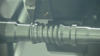 Ağır çekim sahnesi CNC torna makinesi kanalı metal top vida şaft parçalarını kesiyor. CNC dönüşüm makinesinin yüksek teknolojili metal işlemesi .