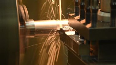 Torna makinesi metal şaft parçalarını sıvı soğutucu metoduyla kesiyor. Makineyi döndürerek metal işleme süreci.