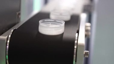 Taşıyıcı banttaki plastik şişe kapaklarının üretimi. İçme suyu üretim sürecinin yüksek teknolojisi. 