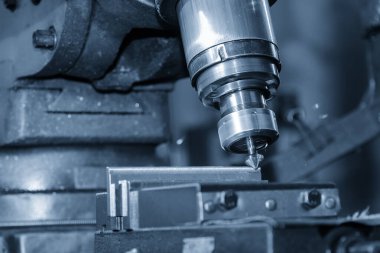 Açık mavi sahnede Chamfer araçlarıyla NC değirmen makinesindeki bölme işlemi. Değirmen makinesindeki metal çalışma konsepti..