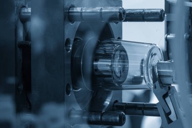 Enjeksiyon küf makinesinin plastik parçaları üretimi. Sahneyi kapat. Mavi sahnede enjeksiyon makinesinin plastik cam parçaları.. 