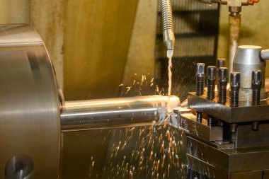 Torna makinesi metal şaft parçalarını sıvı soğutucu metoduyla kesiyor. Makineyi döndürerek metal işleme süreci.