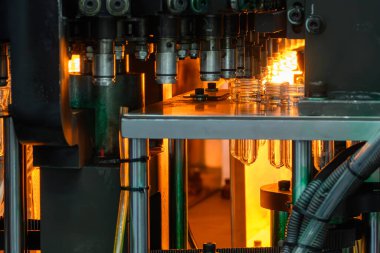 Taşıyıcı bant, önceden şekillendirilmiş şekli üfleme makinesine teslim eder. Plastik şişe üfleme makinesi operasyonu..