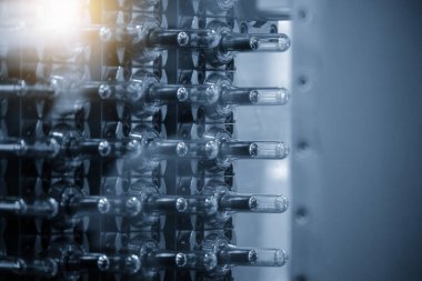 Enjeksiyon işleme grubunu kapatın. Mavi sahnede PET şişe ürünlerinin önceden biçimlendirilmiş hali. PET şişeleri üretim kavramları için ön form şekli.